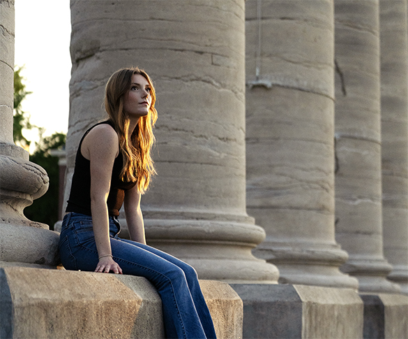 Student sitting at the base of the columns on the Mizzou Quad