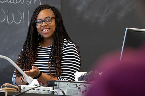 Graduate student teaching assistant in front of classroom